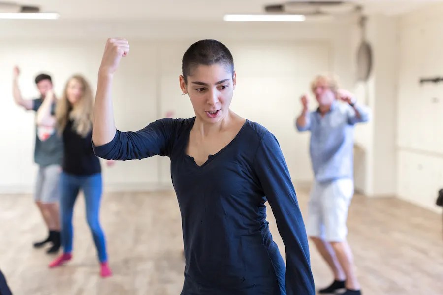 Ania Varez performing in a practice room with people learning behind her