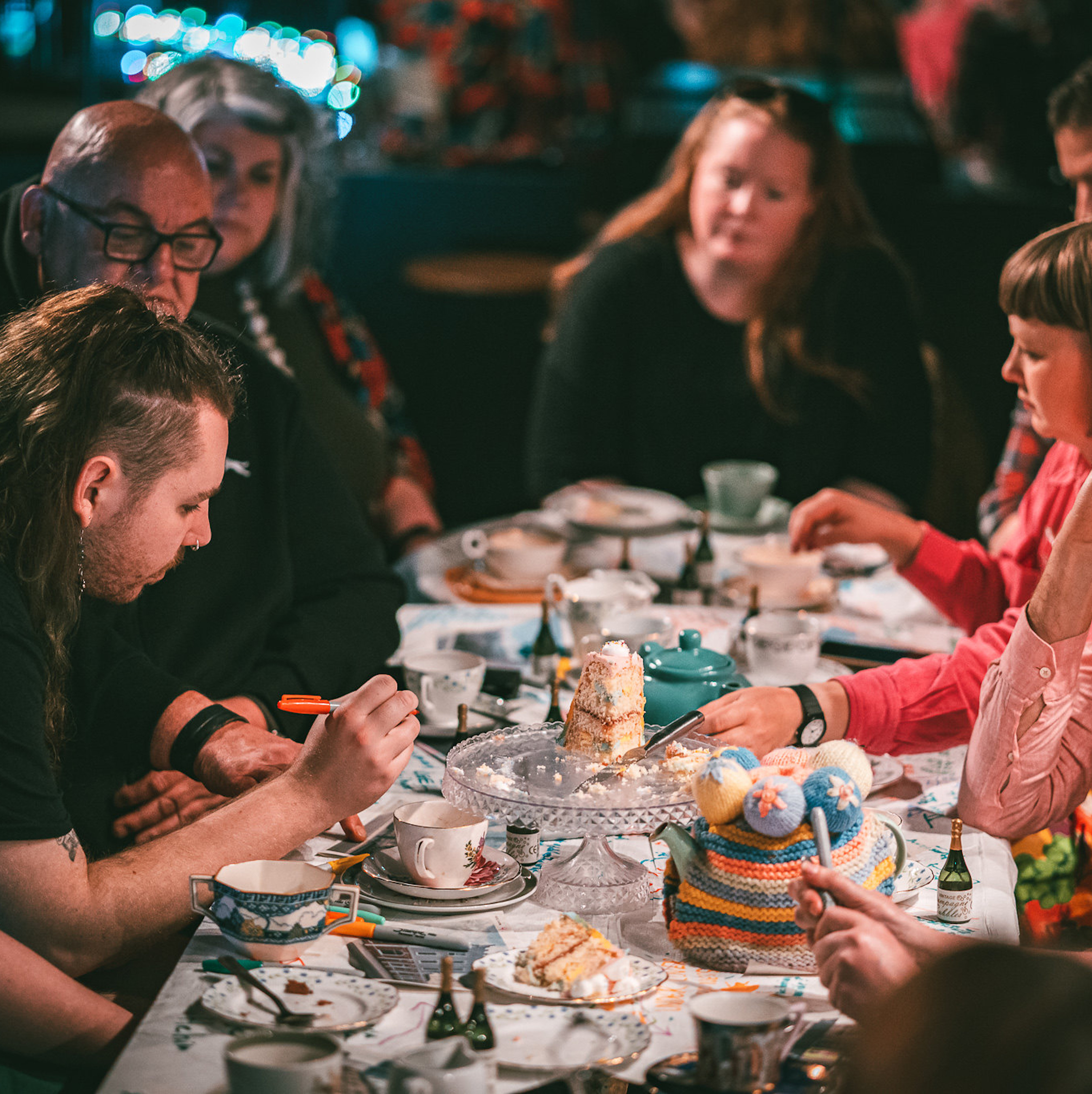 guests at a Section 28 tea party share cake and stories