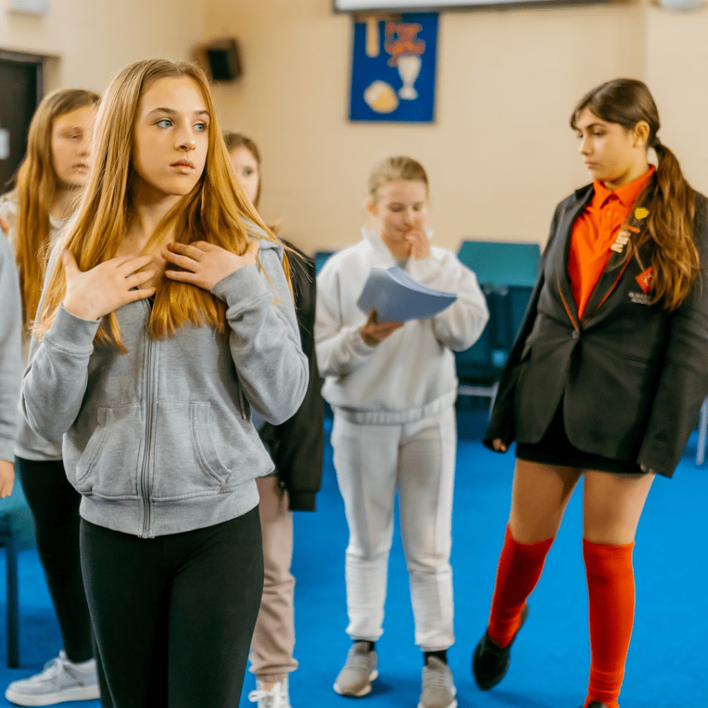 members of the Strike A Light Youth Theatre strike a dramatic pose during a rehearsal session