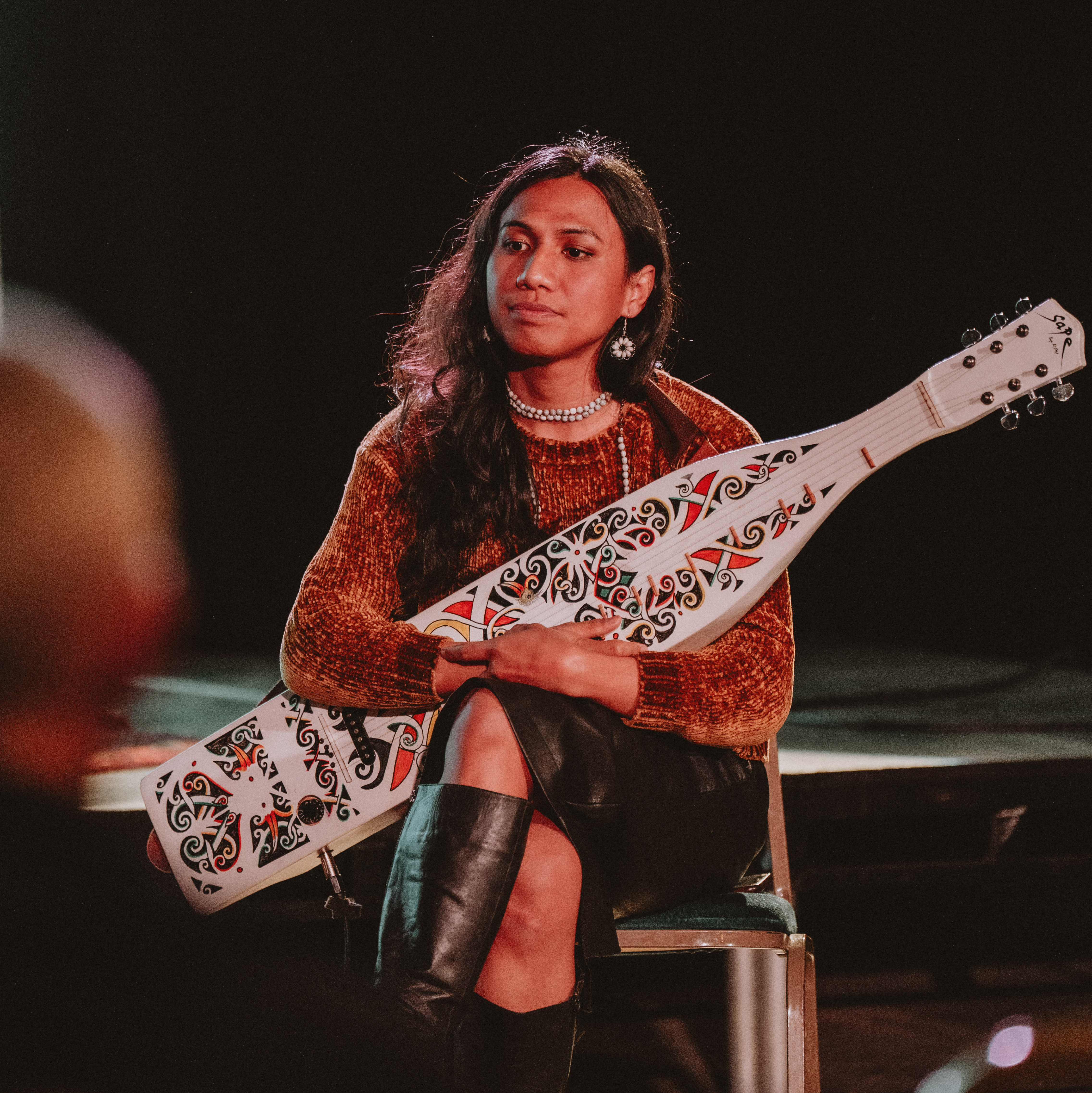 Strike A Light' Community Producer Zariq Hanif holding a Sampe’, a traditional lute from Borneo